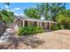 Charming stone home with lush landscaping, a covered porch, and a gravel yard at 528 45Th St, Sarasota, FL 34234
