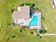 Aerial view of pool and spa with tables and chairs, all enclosed with manicured landscaping and a blue sky at 6209 Heritage Ln # 6209, Bradenton, FL 34209