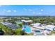 Aerial view displays community recreation center with pools, a water tower, tennis courts, and lush landscaping at 6209 Heritage Ln # 6209, Bradenton, FL 34209