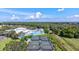 Aerial view of tennis courts and a sparkling swimming pool, surrounded by lush greenery and offering a relaxing community space at 6209 Heritage Ln # 6209, Bradenton, FL 34209