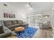 Comfortable living room with sectional sofa, blue rug, and sliding glass doors to the patio at 6209 Heritage Ln # 6209, Bradenton, FL 34209