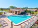 A relaxing view of a shared community pool, featuring lounge chairs and a spa under clear skies at 6209 Heritage Ln # 6209, Bradenton, FL 34209