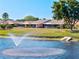 Picturesque view of pond with fountain, mature trees, and well-maintained landscaping near residences at 6209 Heritage Ln # 6209, Bradenton, FL 34209