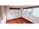 Bright bedroom featuring hardwood floors, white paneling, and large windows with bamboo shades at 624 19Th W St, Bradenton, FL 34205