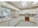 Bright kitchen with white cabinets and appliances, with window into rec room at 6240 7Th W Ave # 6240, Bradenton, FL 34209