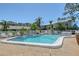 Community pool with clear water surrounded by palm trees and blue sky at 6240 7Th W Ave # 6240, Bradenton, FL 34209