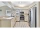 Well-lit kitchen features white cabinetry, stainless steel appliances, and tile flooring at 6415 39Th W Ave, Bradenton, FL 34209