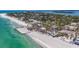 Beautiful beachfront homes line a white sand beach with clear turquoise waters and tropical landscaping in this aerial image at 6603 Gulfside Rd, Longboat Key, FL 34228