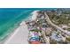 Stunning aerial view of beachfront homes along the white sand with lush palm trees and turquoise waters at 6603 Gulfside Rd, Longboat Key, FL 34228