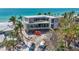Modern beachfront home boasting large windows, elevated design, and beautiful palm trees in an idyllic location at 6603 Gulfside Rd, Longboat Key, FL 34228