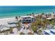 Modern beachfront home featuring elevated design, large windows, and palm trees surrounded by lush landscaping at 6603 Gulfside Rd, Longboat Key, FL 34228