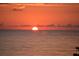 Scenic sunset view over calm ocean waters with a brilliant orange sun and scattered clouds on the horizon at 6603 Gulfside Rd, Longboat Key, FL 34228