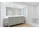Modern bathroom with double vanity, large mirror, and a glass-enclosed shower at 6628 Keystone Dr, Sarasota, FL 34231