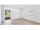 Bright bedroom with light wood floors, white walls, and a sliding door to the backyard at 6628 Keystone Dr, Sarasota, FL 34231