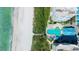 An aerial view of a beachfront property with a pool, condos, a white sand beach and clear ocean waters at 675 Longboat Club Rd # 23A, Longboat Key, FL 34228