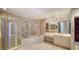 Luxurious bathroom with marble tiling, shower, soaking tub, and vanity area at 675 Longboat Club Rd # 23A, Longboat Key, FL 34228