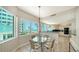 Cozy dining area with a round glass-top table, four chairs, and beach and ocean views at 675 Longboat Club Rd # 23A, Longboat Key, FL 34228