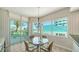 Casual dining area with views of the golf course, floor-to-ceiling glass doors to the balcony, and chandelier at 675 Longboat Club Rd # 23A, Longboat Key, FL 34228