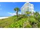 Beachside condo with palm trees and lush vegetation in view at 675 Longboat Club Rd # 23A, Longboat Key, FL 34228
