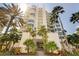 Majestic high-rise condominium with sprawling balconies, towering palm trees, and sunny skies at 675 Longboat Club Rd # 23A, Longboat Key, FL 34228