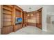 Living room with custom wood built-ins, tile flooring and recessed lighting at 675 Longboat Club Rd # 23A, Longboat Key, FL 34228