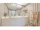 Well-lit bathroom features double sinks, decorative wallpaper, and ample counter space at 6770 Fairway Gardens Dr, Bradenton, FL 34203