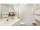 Bright bathroom features floral wallpaper, a shower with tub, and a vanity with mirror at 6770 Fairway Gardens Dr, Bradenton, FL 34203