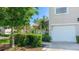 Exterior view showing two-car garage and home address surrounded by trees at 6770 Fairway Gardens Dr, Bradenton, FL 34203