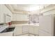 Bright kitchen with white cabinets, modern appliances, mosaic tile backsplash, and pass-through to another room at 6770 Fairway Gardens Dr, Bradenton, FL 34203