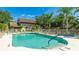 Community pool with clear water and plenty of lounge chairs and umbrellas on deck at 6770 Fairway Gardens Dr, Bradenton, FL 34203