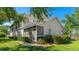 Rear exterior view featuring a screened-in porch and lush landscaping at 6770 Fairway Gardens Dr, Bradenton, FL 34203