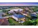 An aerial view showcases a home with a screened-in pool and surrounding landscape near a lake at 7538 Camden Harbour Dr, Bradenton, FL 34212