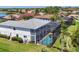 Aerial view of a home with a screened-in pool area, lush landscaping, and surrounding neighborhood at 7538 Camden Harbour Dr, Bradenton, FL 34212