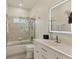 Bathroom with a walk-in shower, tiled walls, white vanity, and lighted mirror at 7538 Camden Harbour Dr, Bradenton, FL 34212