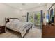 Cozy bedroom with vaulted ceiling, fan, and sliding door to a balcony overlooking trees at 7538 Camden Harbour Dr, Bradenton, FL 34212