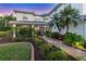 Charming home entrance with a brick walkway, lovely landscaping, and a screened porch at 7538 Camden Harbour Dr, Bradenton, FL 34212