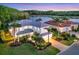 Stunning lakefront home with lush landscaping, a tile roof, and a brick driveway at 7538 Camden Harbour Dr, Bradenton, FL 34212