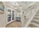 Bright, spacious foyer with staircase, stylish lighting, and glass-paneled front doors at 7538 Camden Harbour Dr, Bradenton, FL 34212