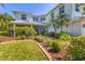 Lovely front yard with lush landscaping and beautiful lawn leading up to the white two-story home at 7538 Camden Harbour Dr, Bradenton, FL 34212