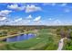 Aerial view of a well-maintained golf course with a lake, green fairways, and cart path at 7538 Camden Harbour Dr, Bradenton, FL 34212