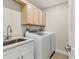 Bright laundry room featuring a sink and white front loading washer and dryer at 7538 Camden Harbour Dr, Bradenton, FL 34212