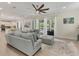 Open living room featuring light-colored furniture, tile floors and sliding doors to the pool area at 7538 Camden Harbour Dr, Bradenton, FL 34212