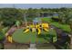 Aerial view of a fenced playground with slides and climbing equipment surrounded by landscaping at 7538 Camden Harbour Dr, Bradenton, FL 34212