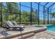 Beautiful screened-in pool and spa with lounge chairs and lush greenery create a private and relaxing oasis at 7538 Camden Harbour Dr, Bradenton, FL 34212
