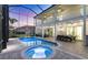 An outdoor pool is surrounded by a covered patio, outdoor dining area, and a screened enclosure at 7538 Camden Harbour Dr, Bradenton, FL 34212