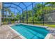 Backyard oasis featuring a screened-in pool, brick pavers, and lush landscaping at 7538 Camden Harbour Dr, Bradenton, FL 34212