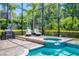 Inviting screened-in pool and spa area, perfect for outdoor relaxation and entertainment with lounge chairs and a grill at 7538 Camden Harbour Dr, Bradenton, FL 34212