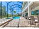 Spacious screened-in pool area with spa, outdoor bar, dining space, and backyard views, perfect for entertaining at 7538 Camden Harbour Dr, Bradenton, FL 34212