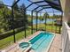 Screened in pool and spa with a view of the lake and green backyard at 7538 Camden Harbour Dr, Bradenton, FL 34212