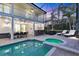 A pool and hot tub surrounded by an outdoor dining area and screened enclosure for outdoor living at 7538 Camden Harbour Dr, Bradenton, FL 34212